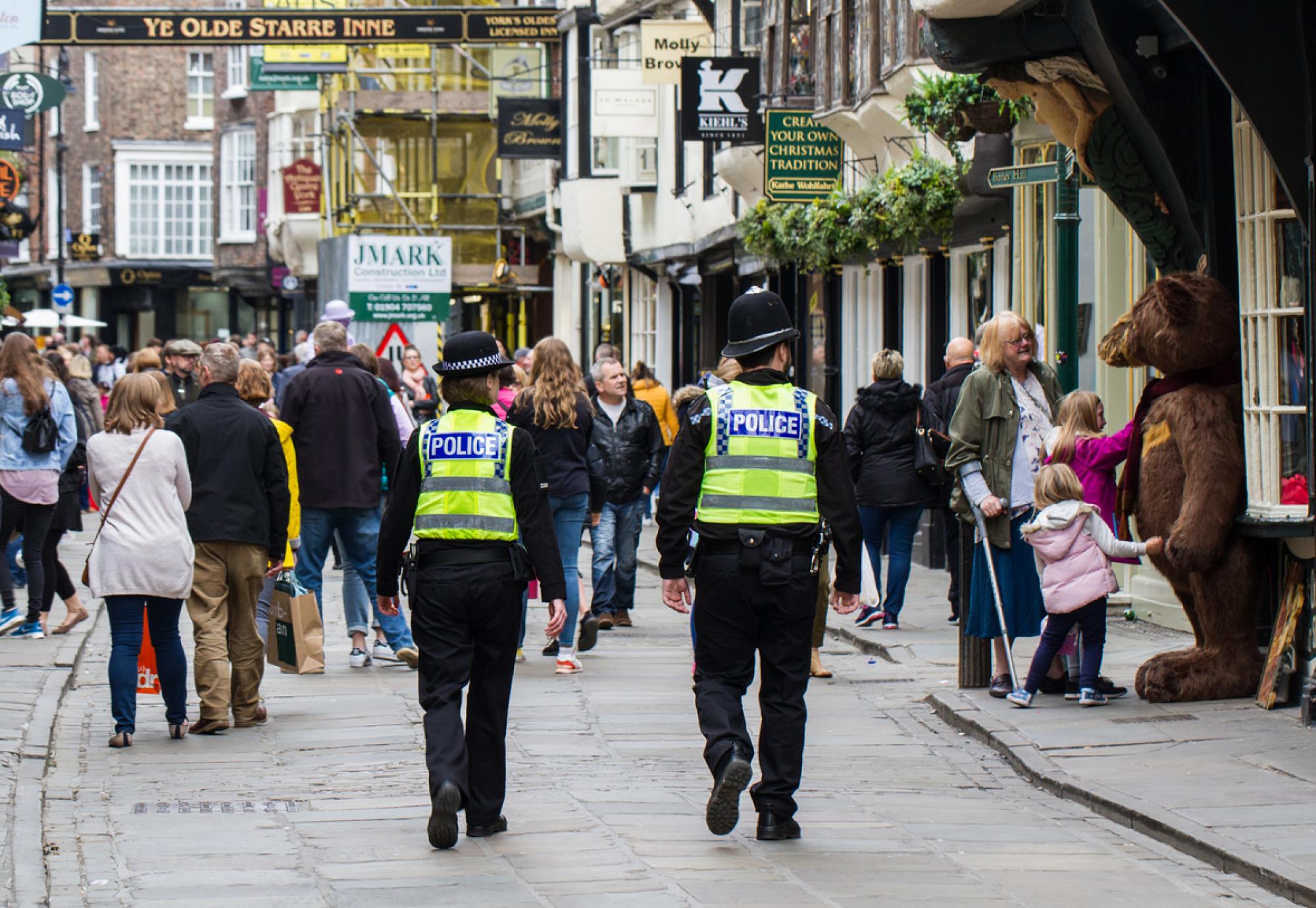 A pair of British policemen and woman on patrol on the streets of York