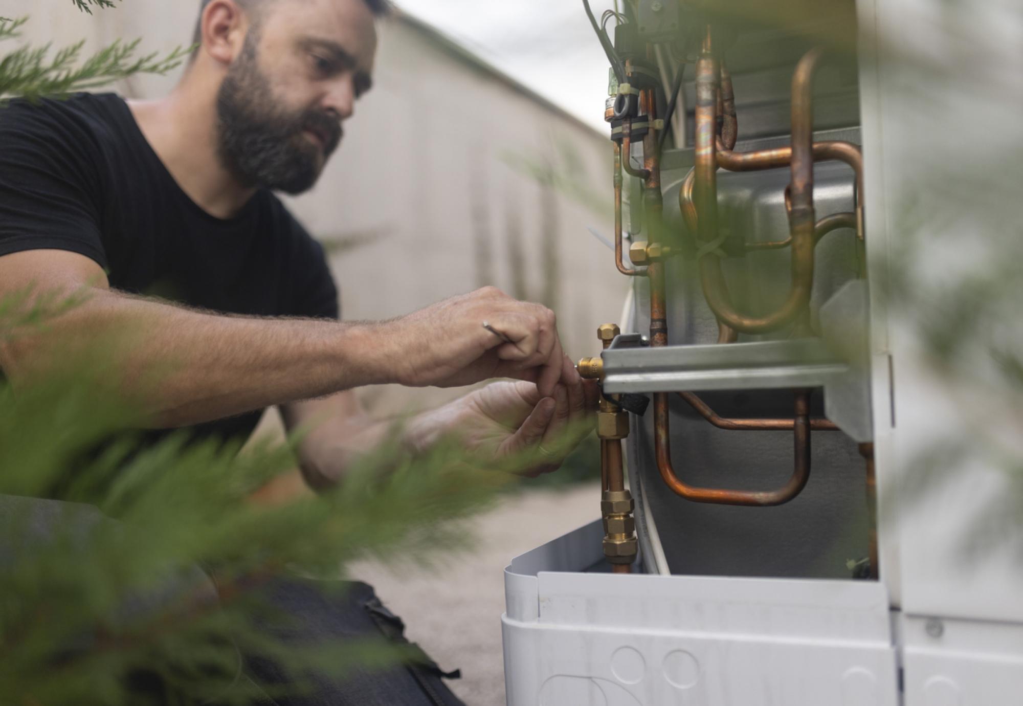 Technician installing a heat pump in the yard