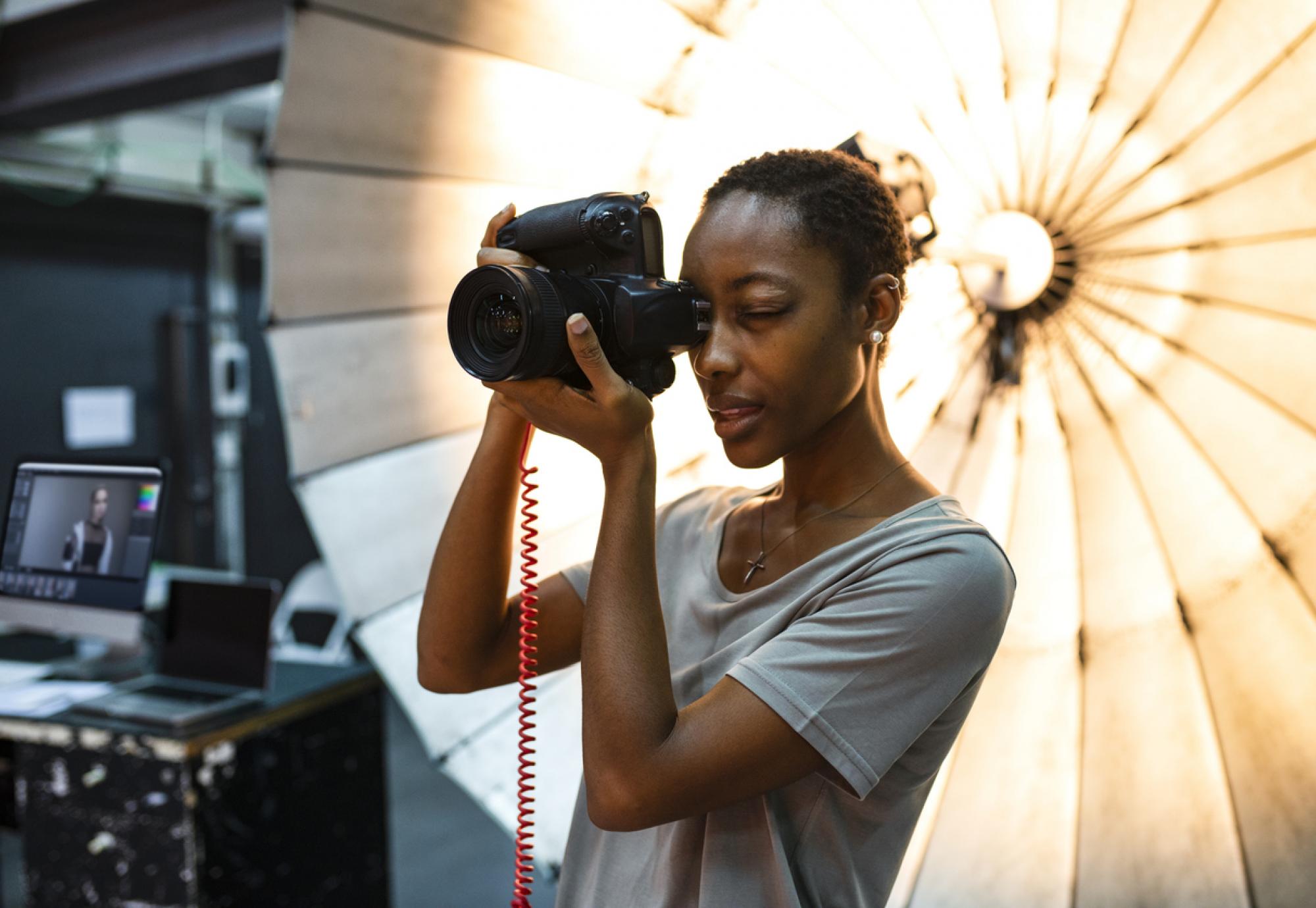 Young photographer standing in front of a reflective umbrella