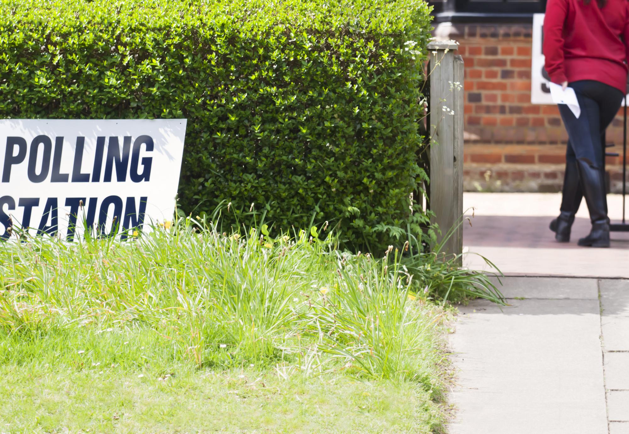 a woman taking her polling card to cast her vote