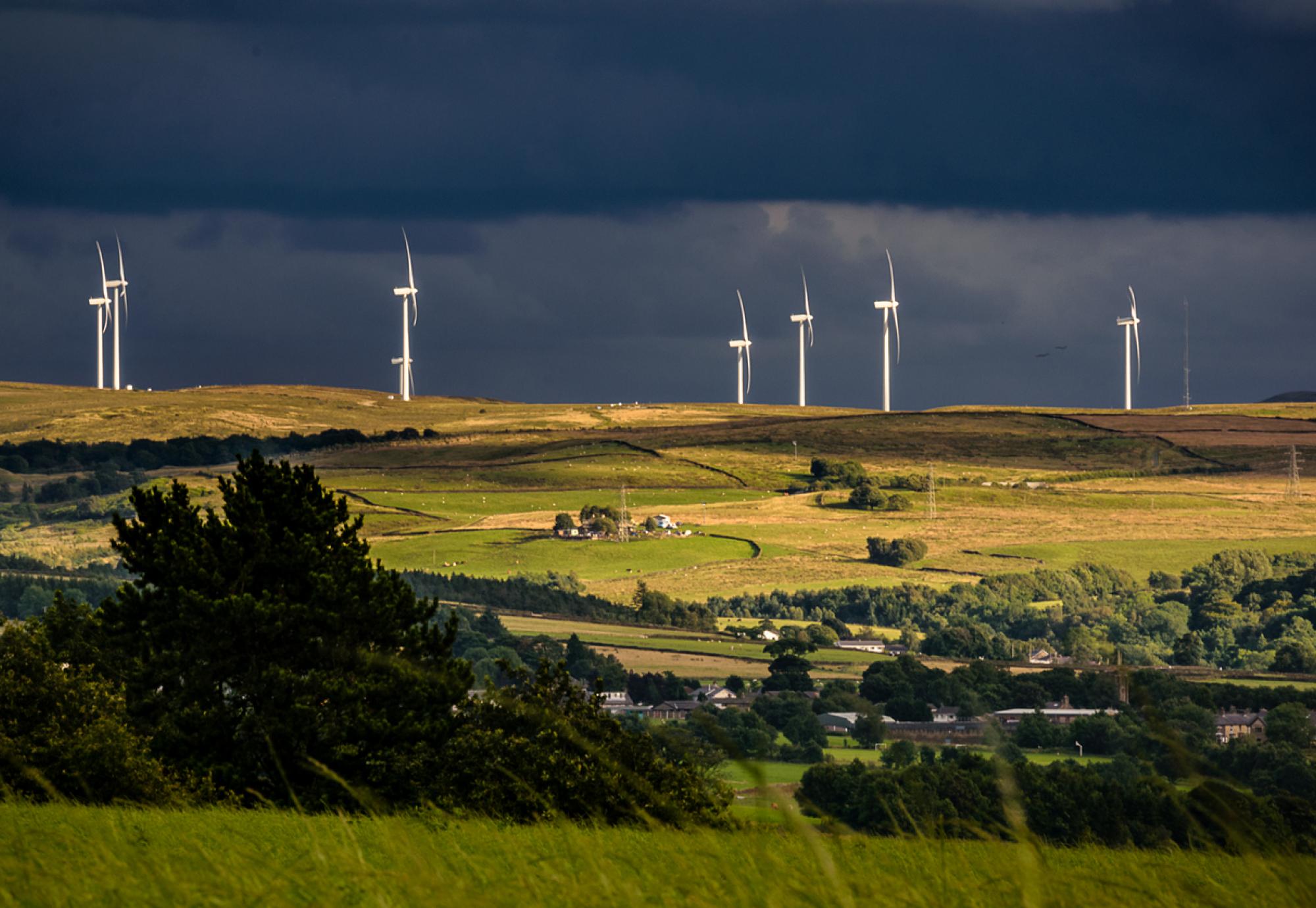 wind turbines and clouds over a farm and hills in Lancashire, England UK