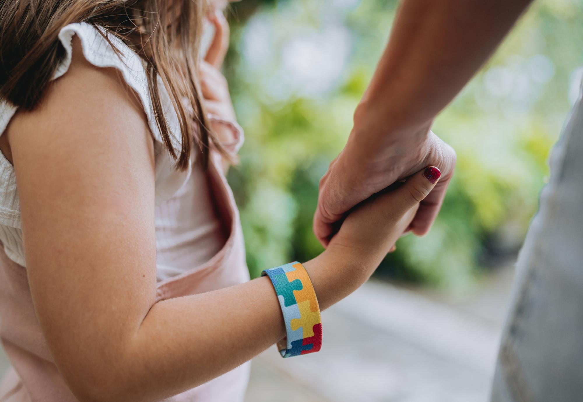 Girl holds adults hand