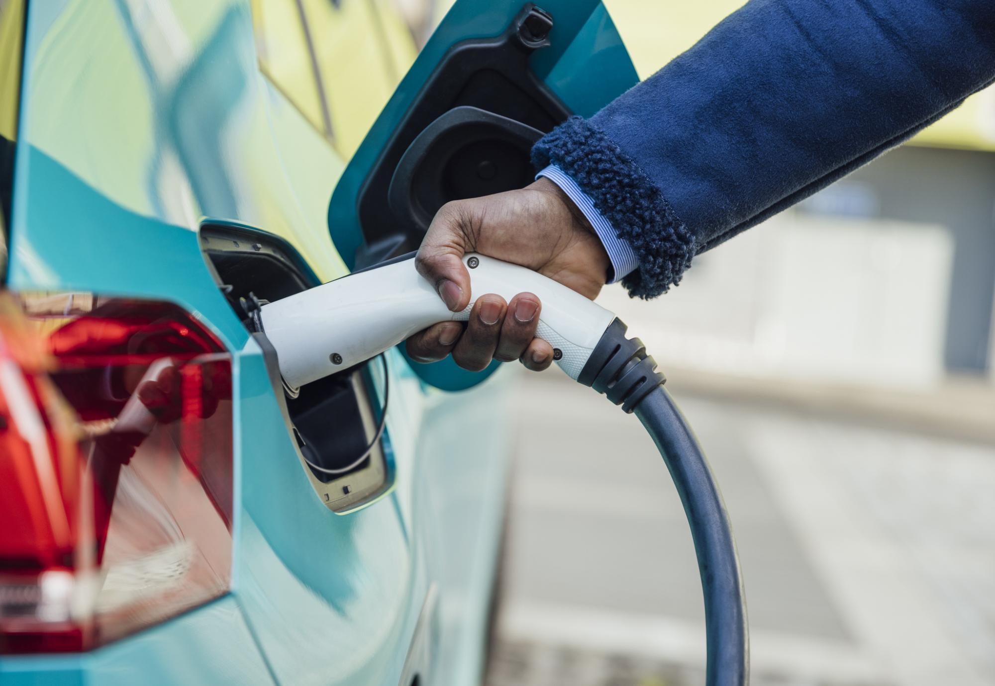 Man plugging an electric care into a charger