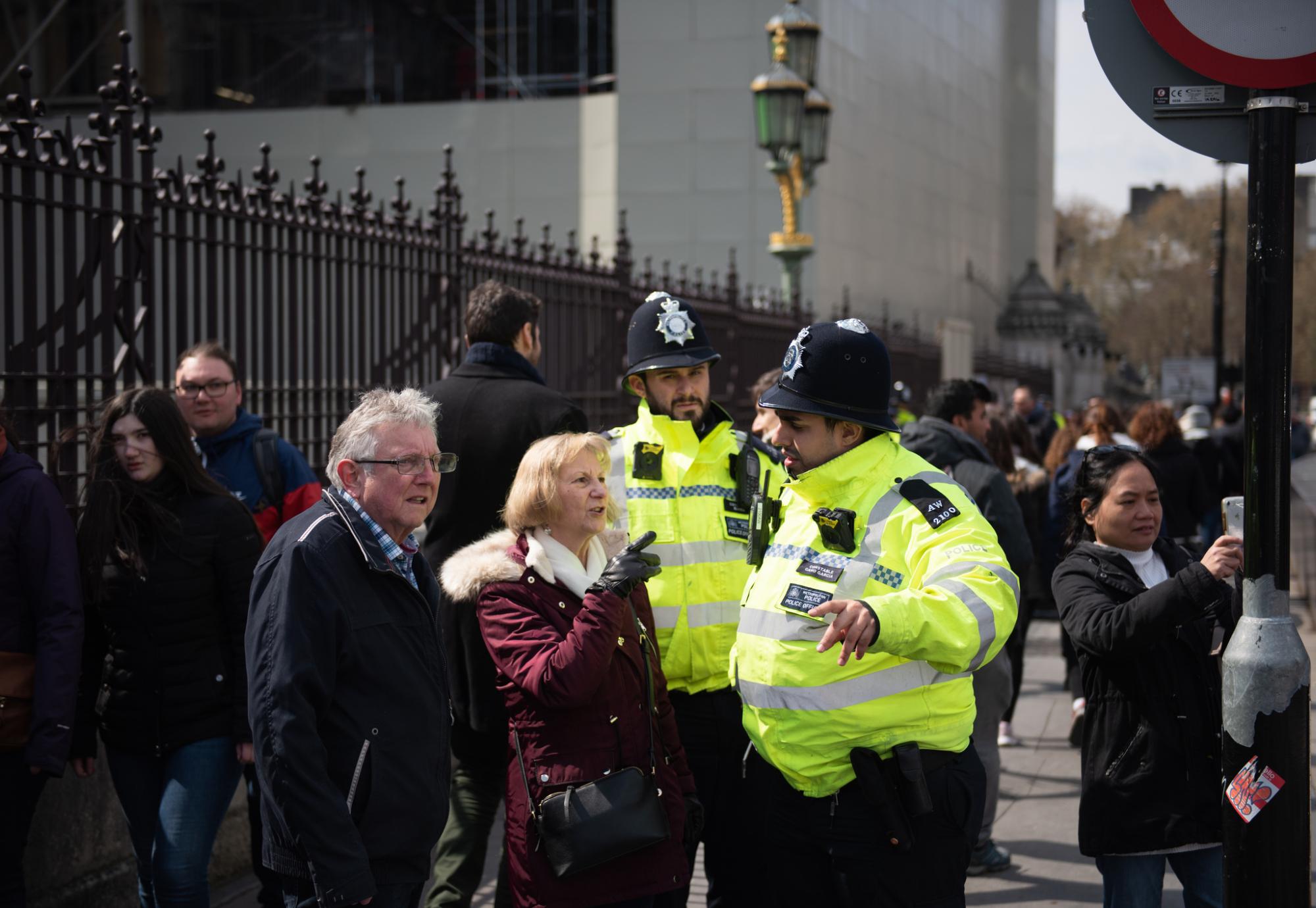 Two police officers helping people