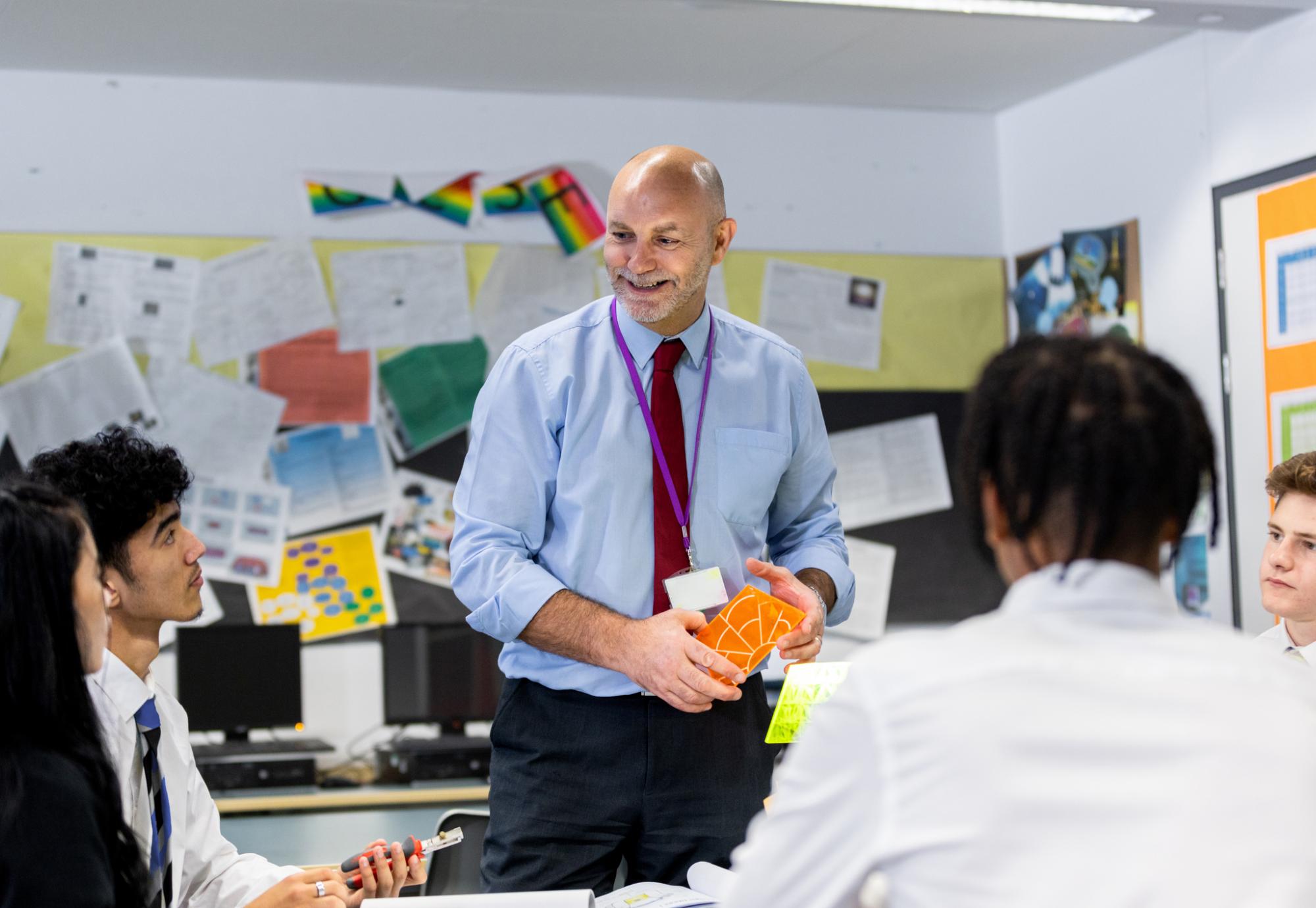 school teacher teaching his students in a high school