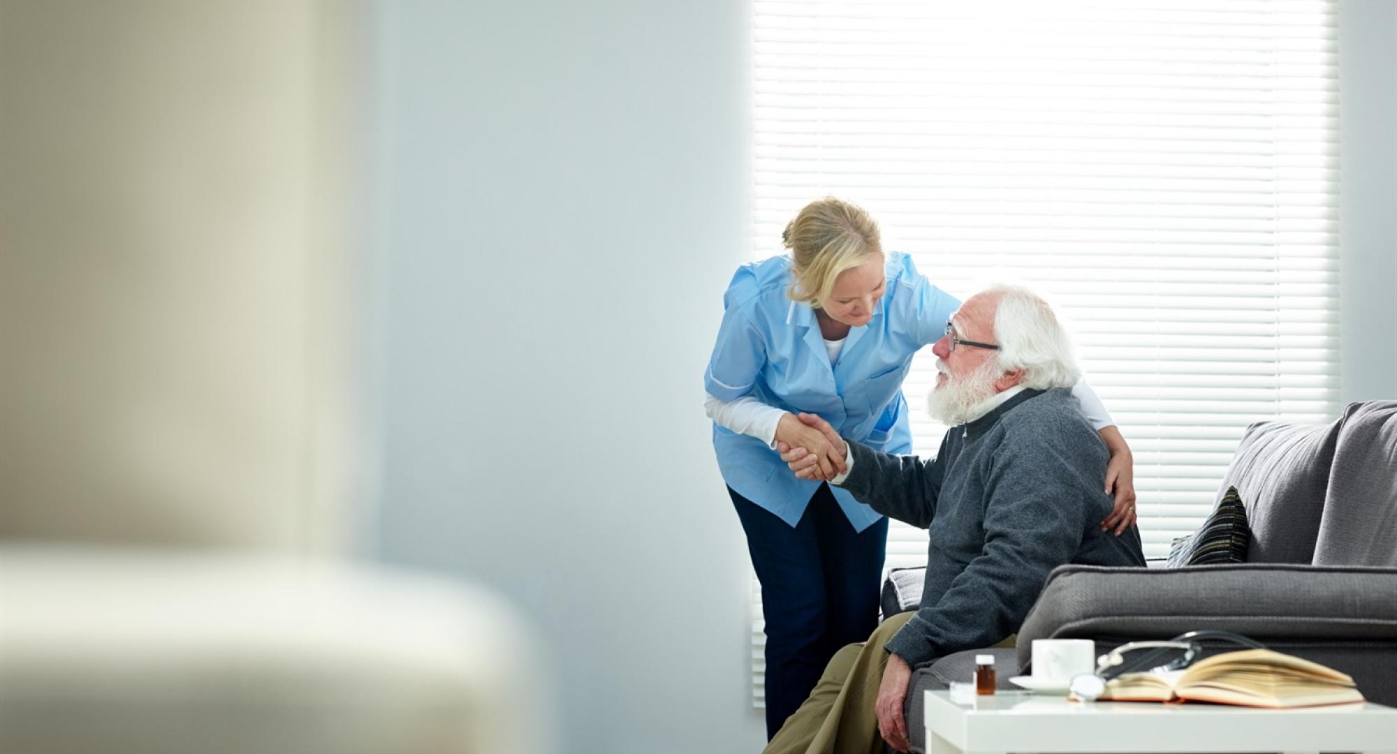 Carer helping elderly man