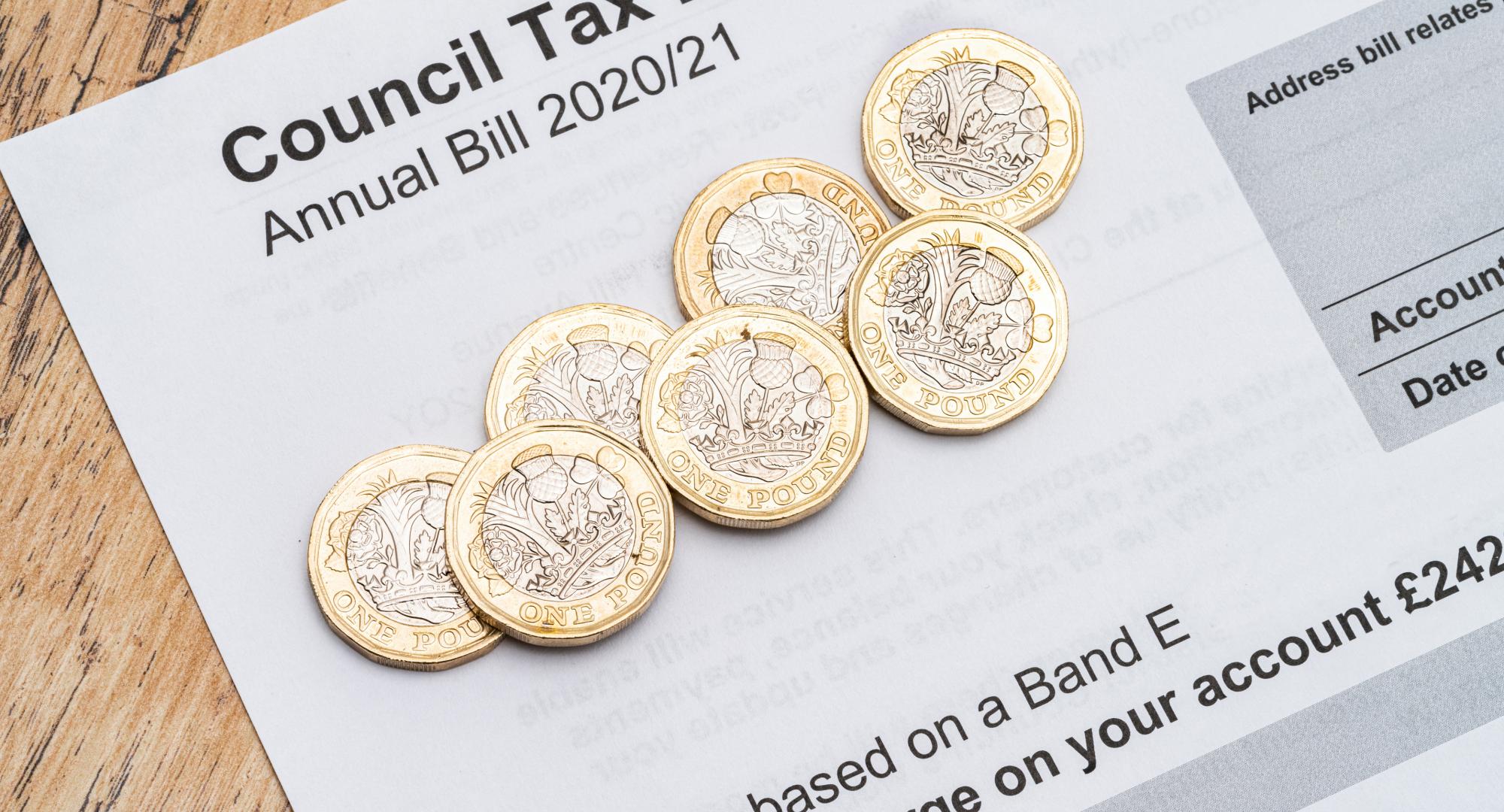 Council tax bill with coins on top.