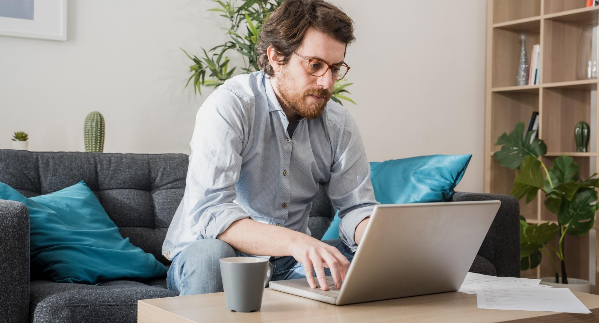 Man sits at computer, working from home.