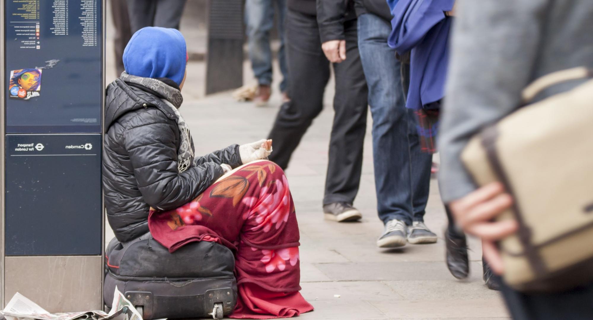 Homeless person asks passersby for money