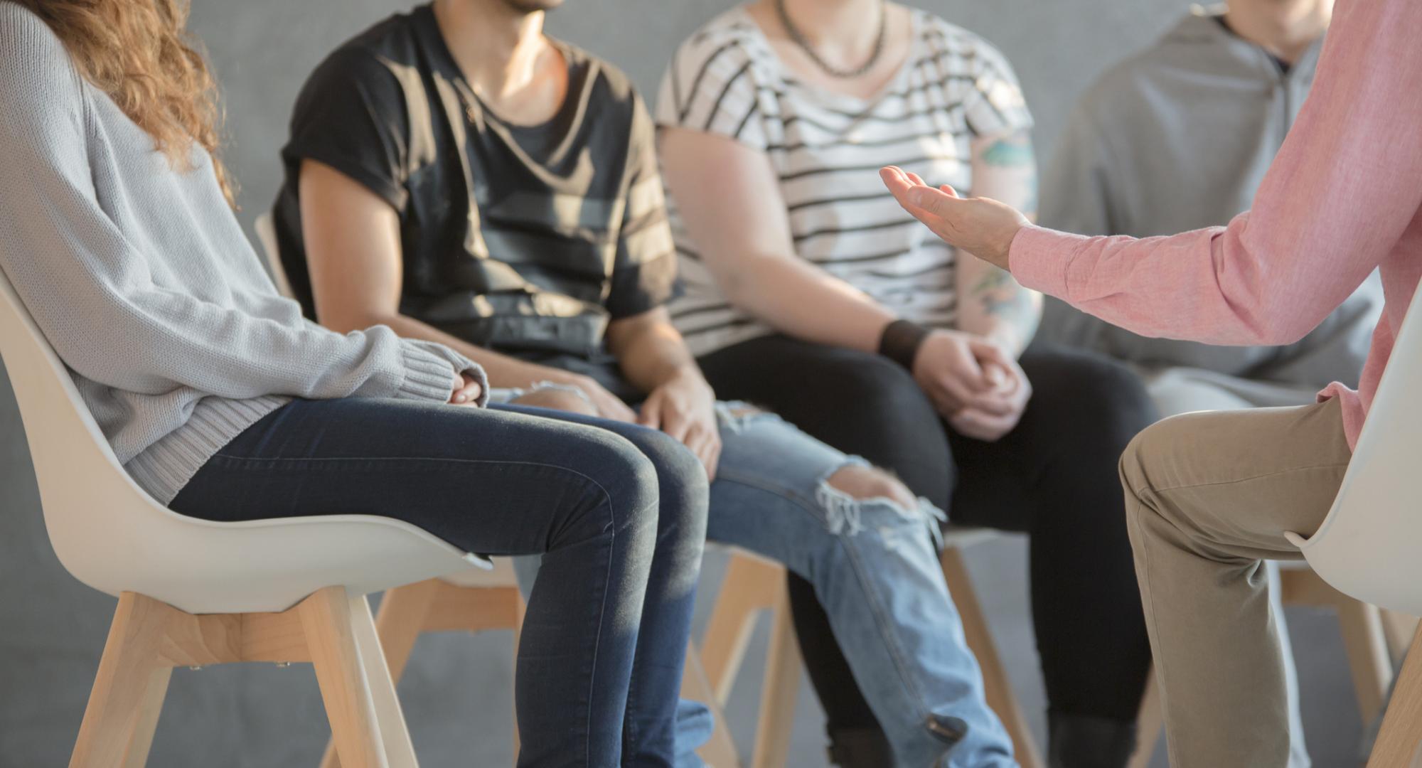 Counsellor sat talking with young people about mental health. 