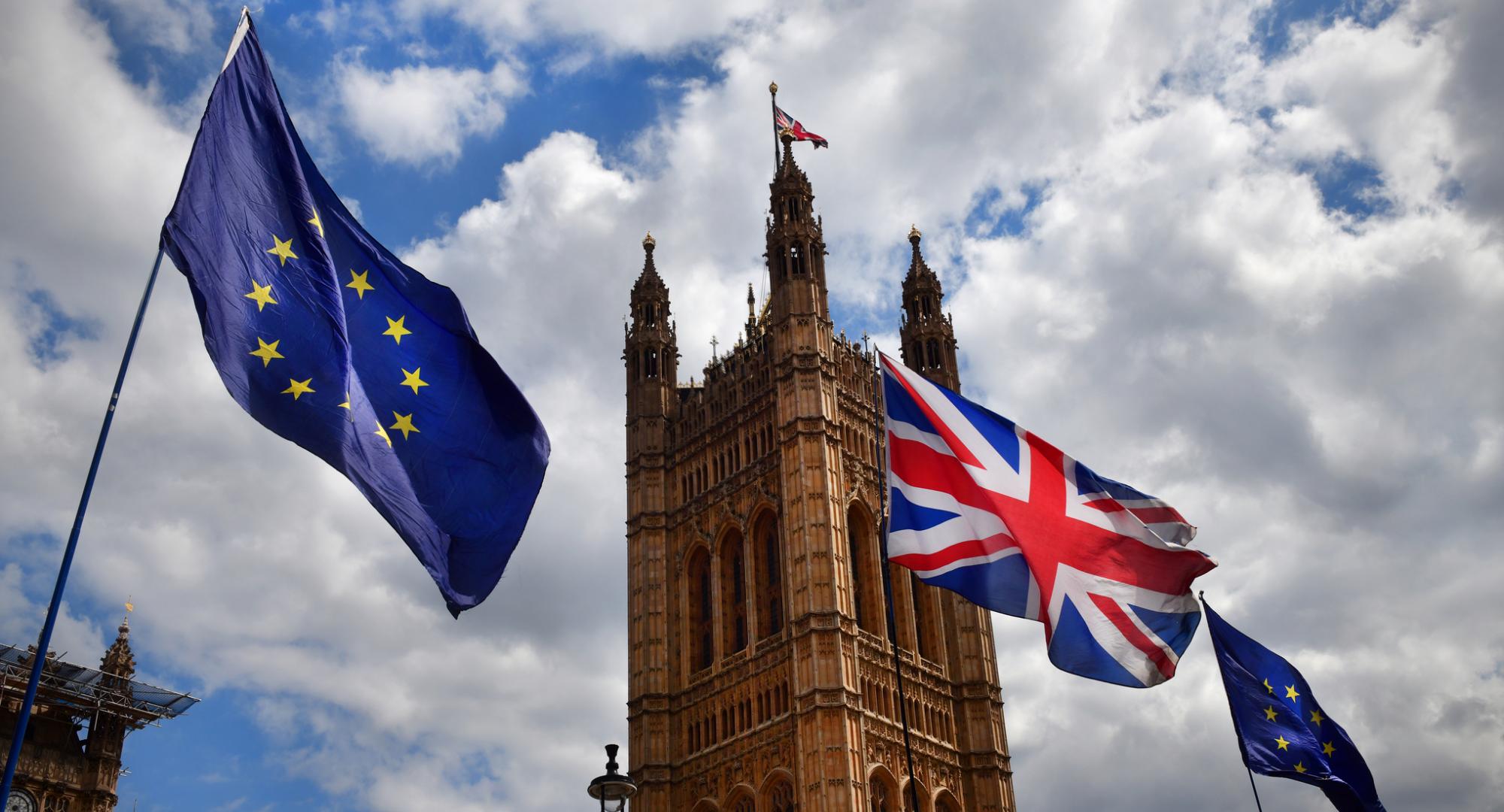 EU and Union Flag fly next to Parliament.