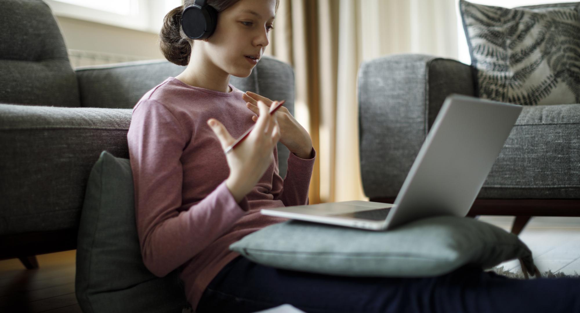 Girl sits in front of laptop remote learning