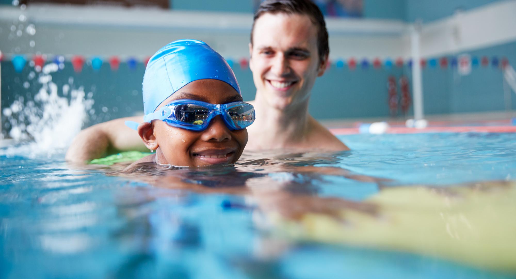 Boy with male swimming coach