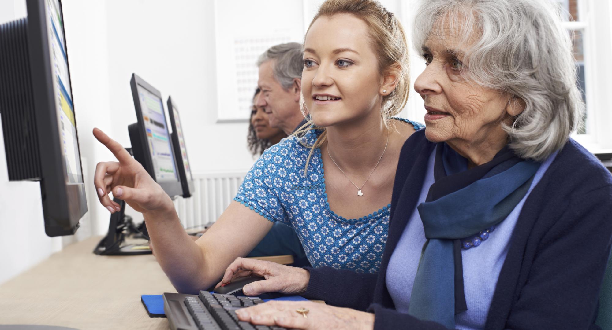 Elderly resident being taught to use a computer