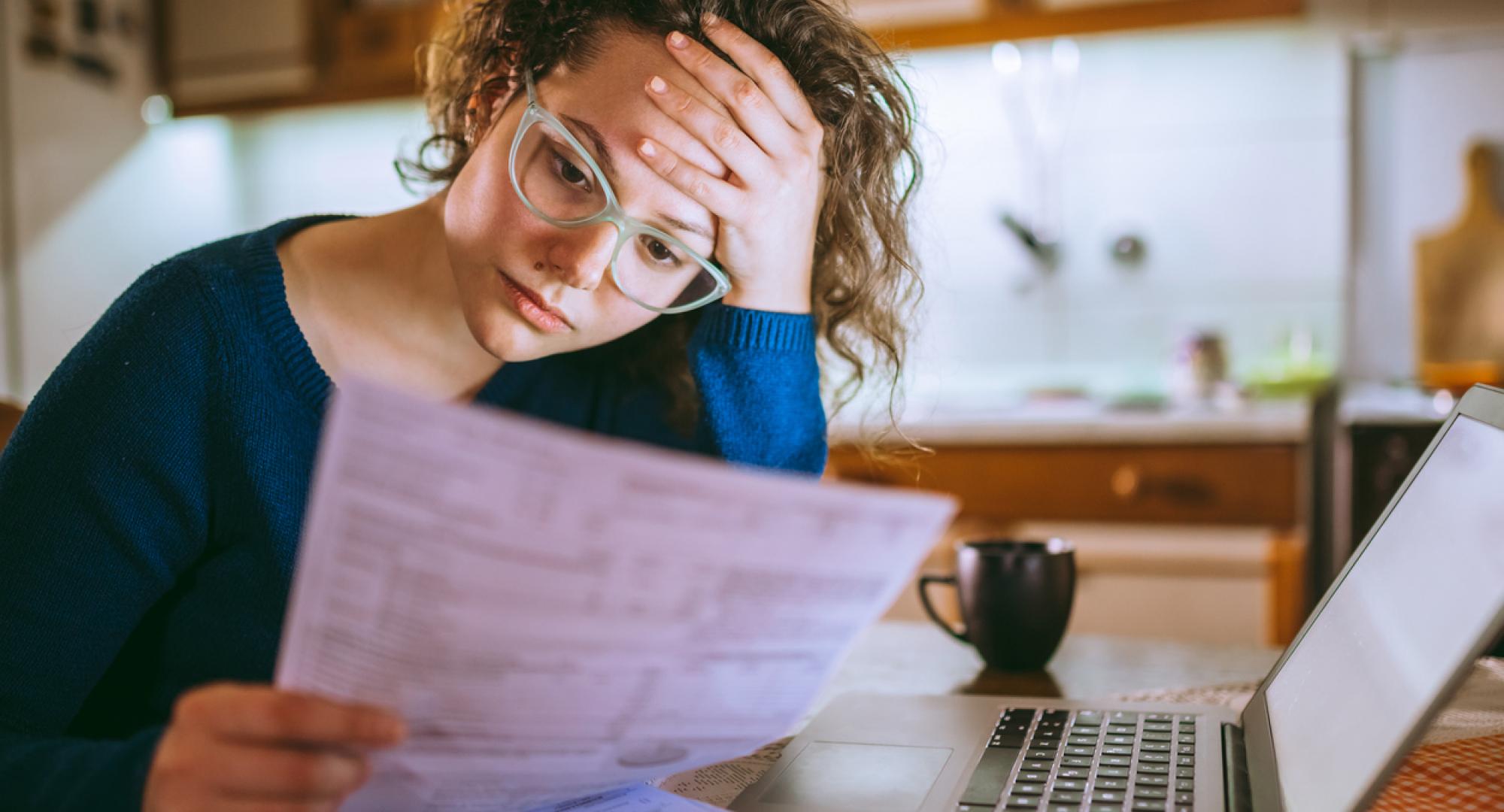 Young woman looking upset at her bill