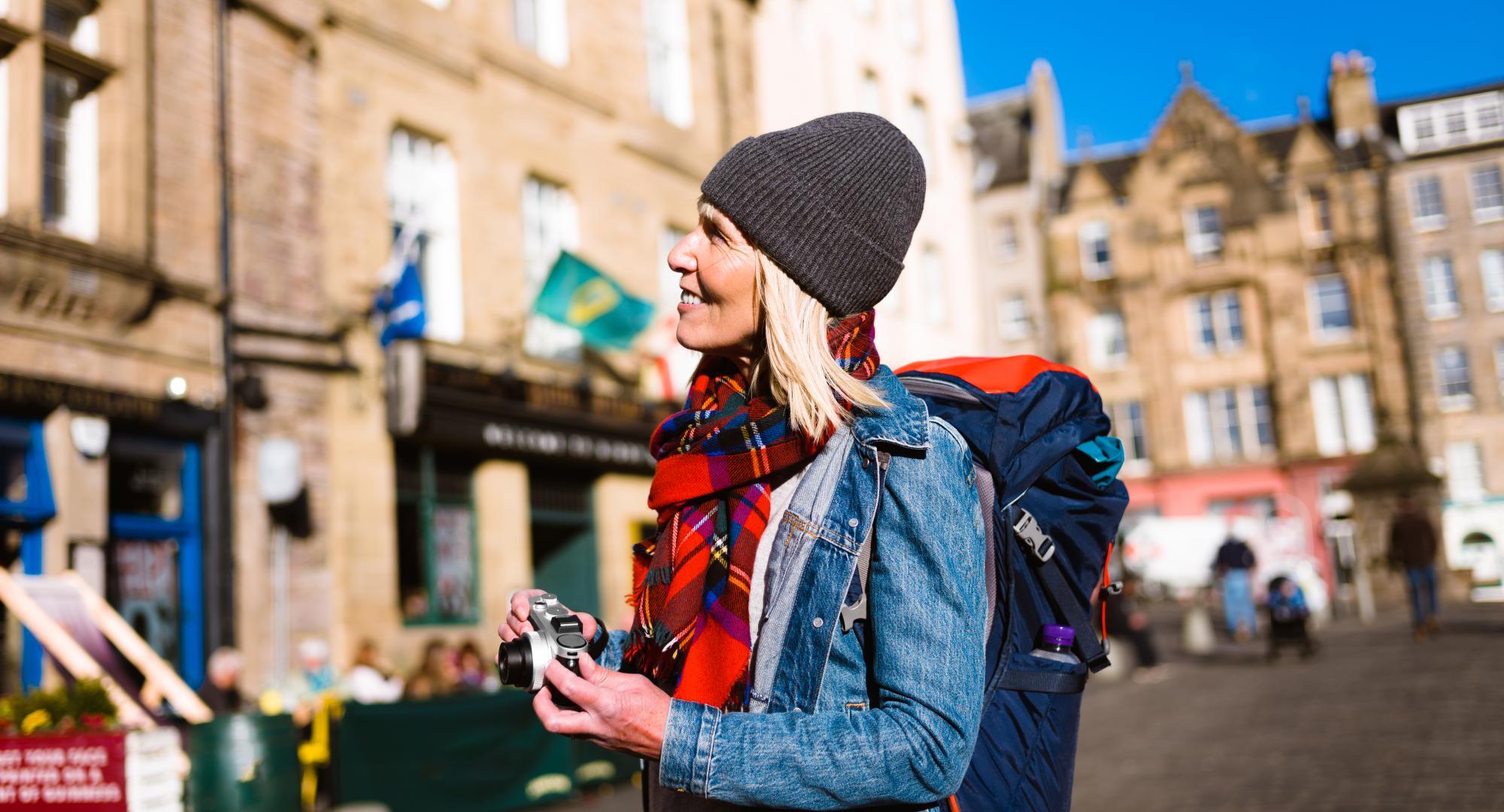 Tourist photographing at the Grassmarket, Edinburgh, Scotland.