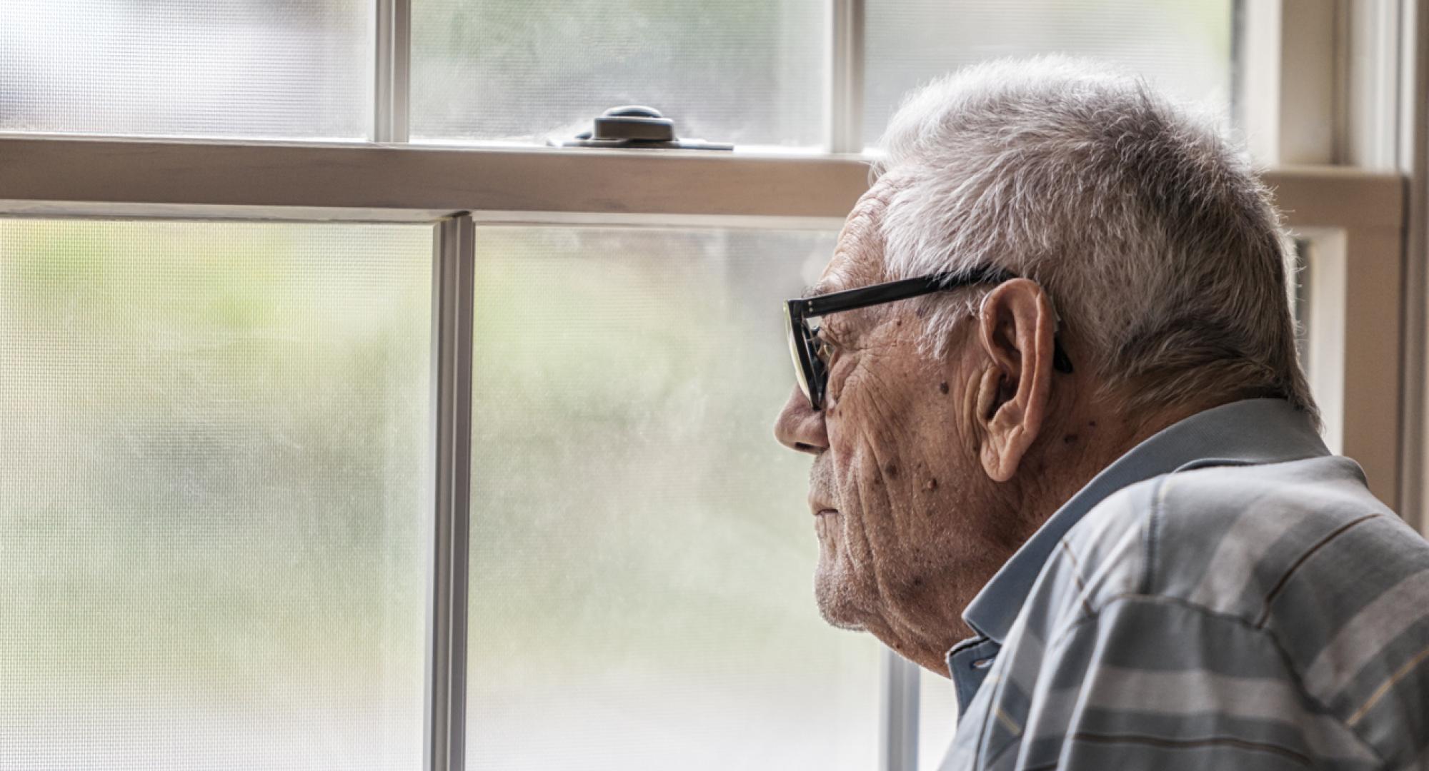 Wistful Senior Man Staring Through Hazy Window