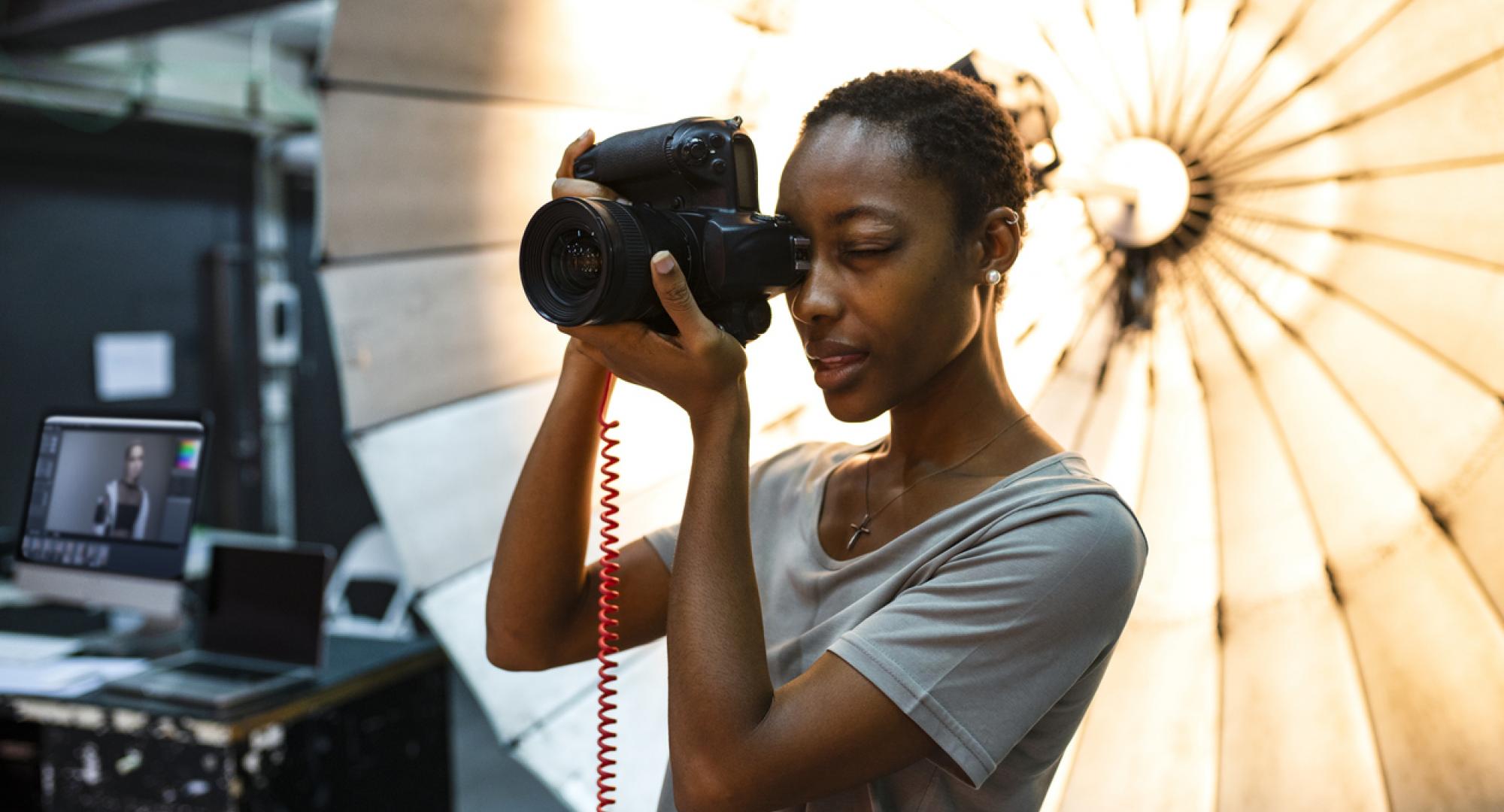 Young photographer standing in front of a reflective umbrella