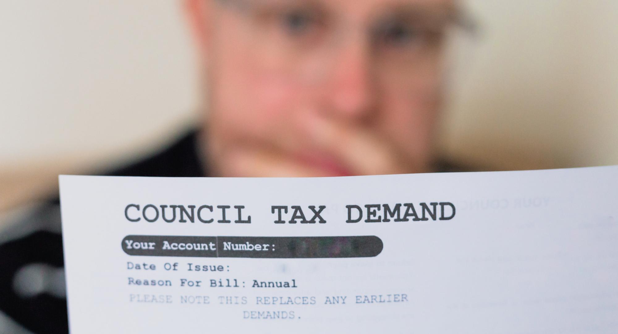 Worried man checking council tax bill