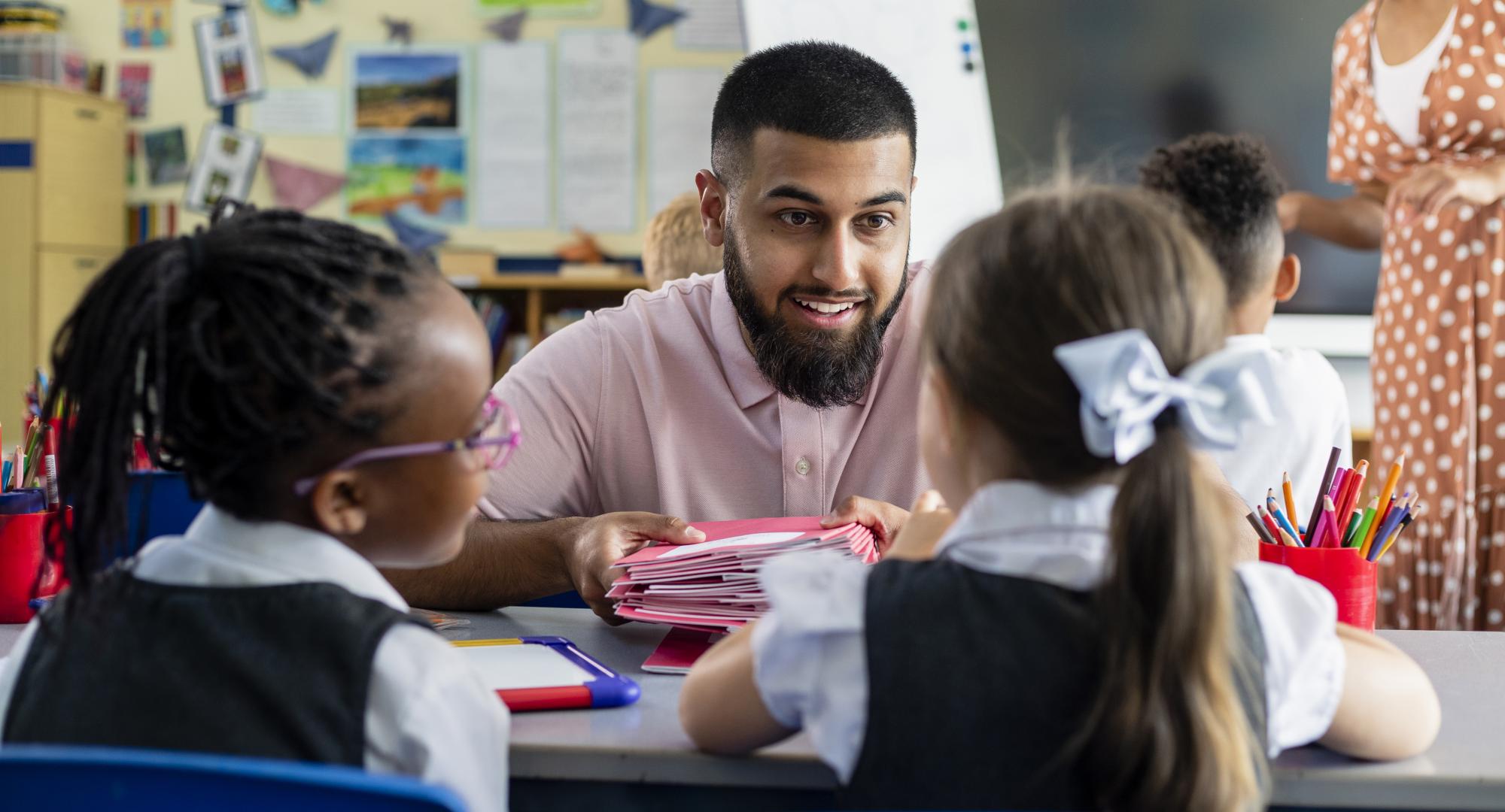 A teacher working with two primary school students