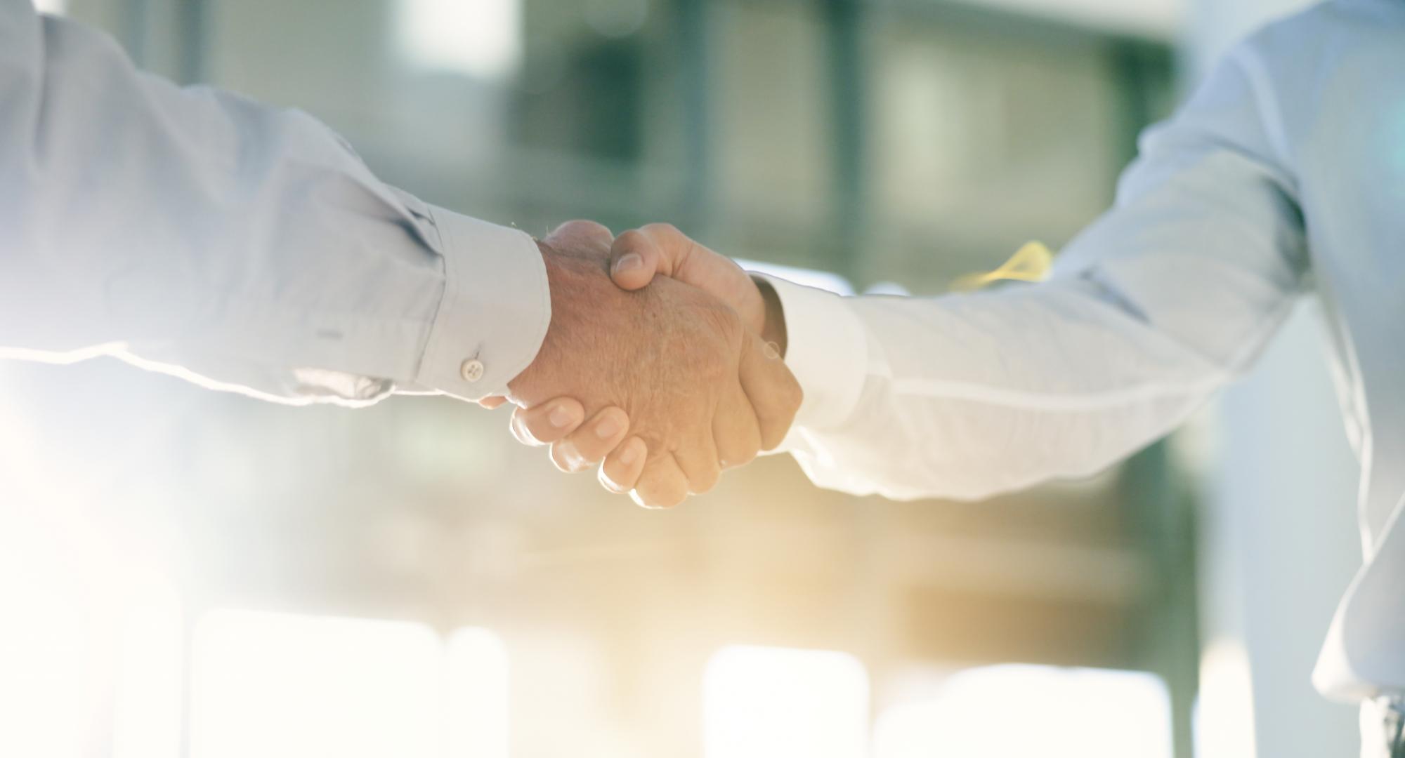 Two men shake hands on an office