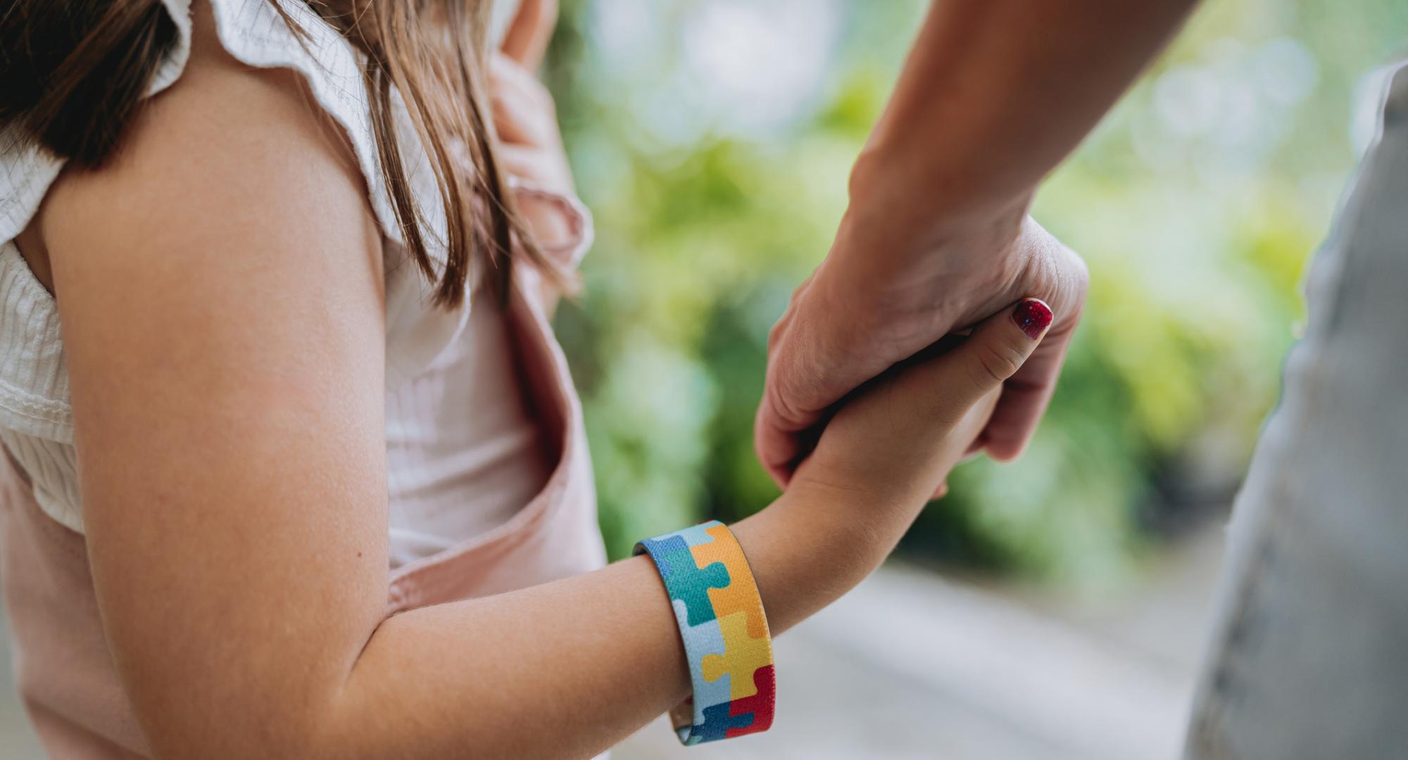 Girl holds adults hand