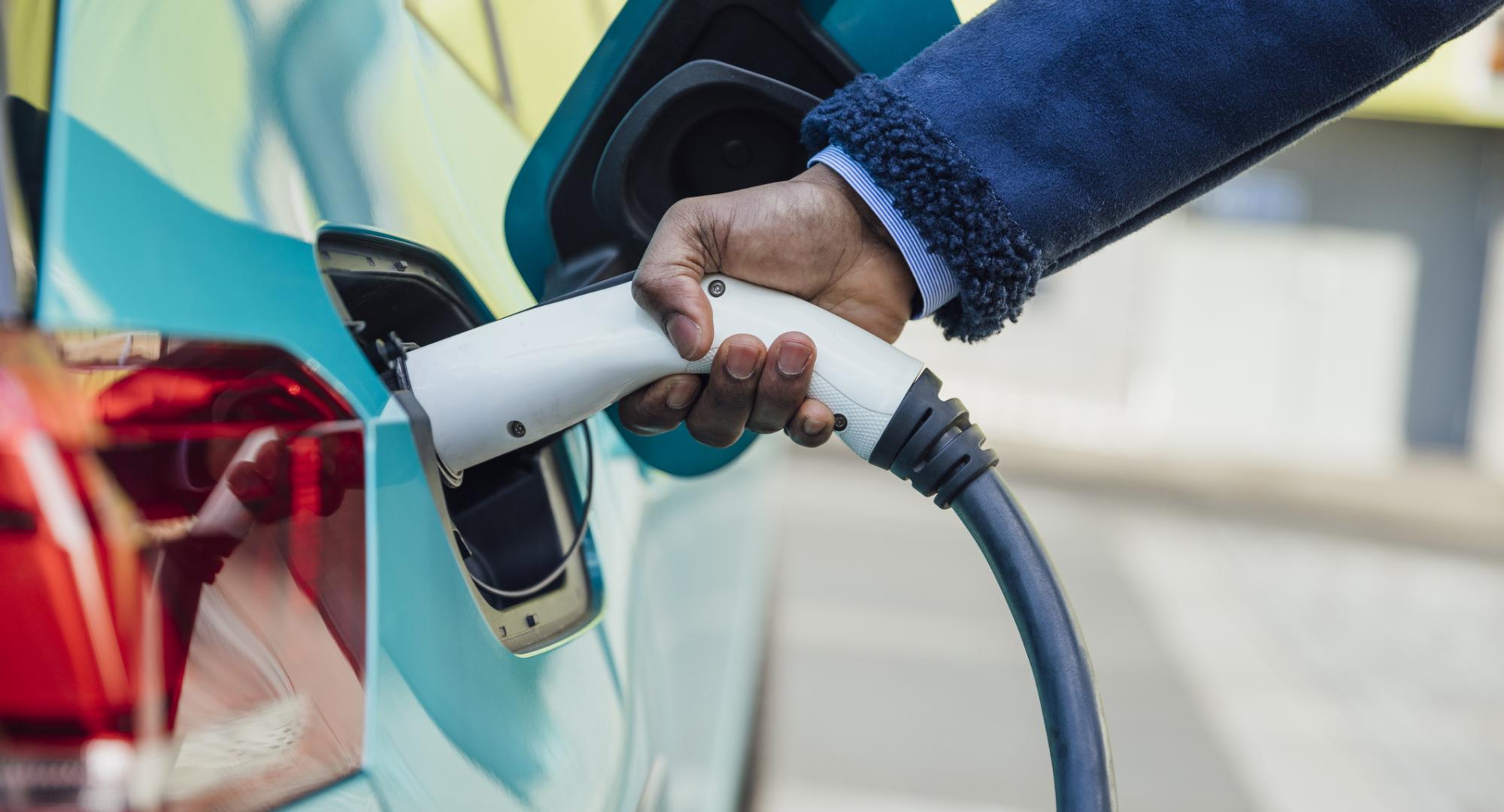 Man plugging an electric care into a charger