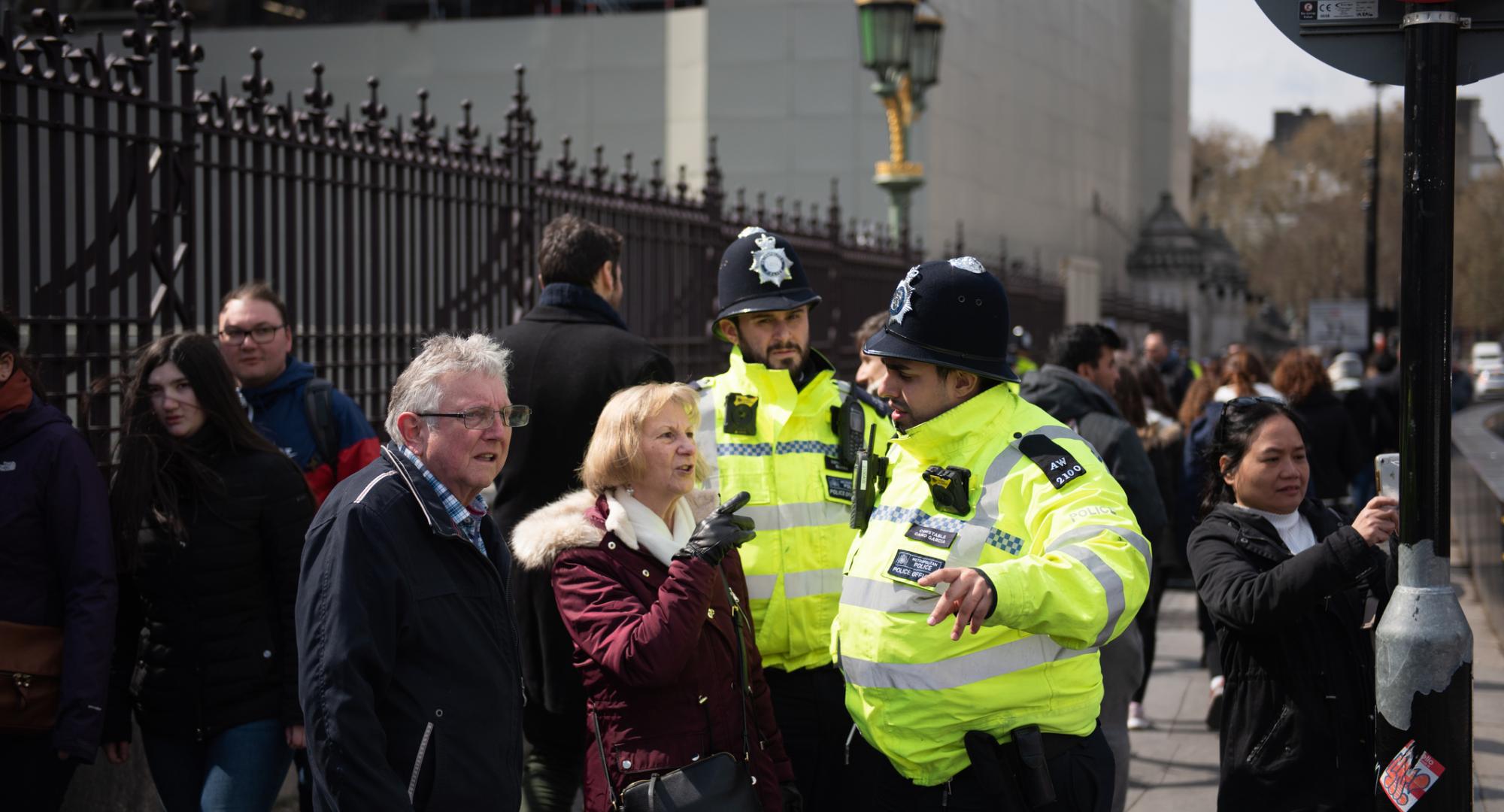 Two police officers helping people