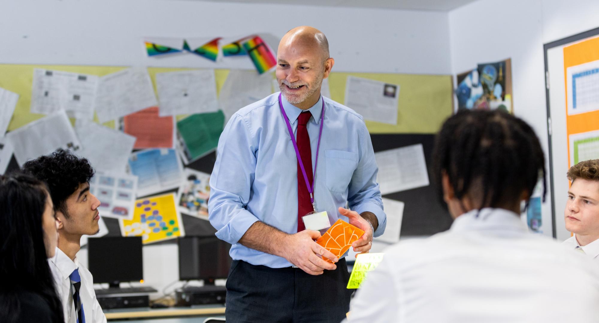 school teacher teaching his students in a high school