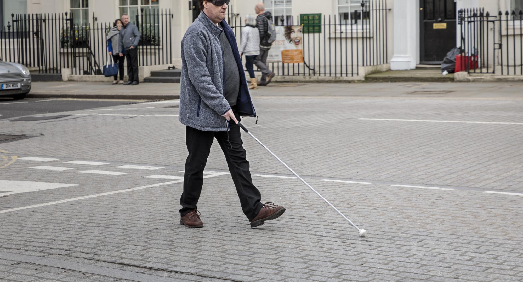 Blind man crossing the road in London