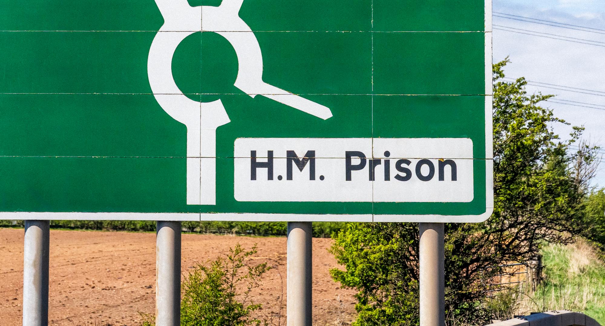 Prison sign next to a road