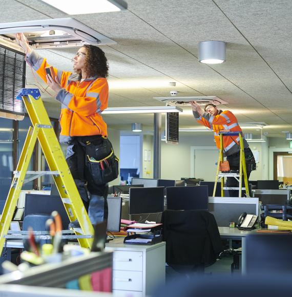 Technicians changing lights in an office building
