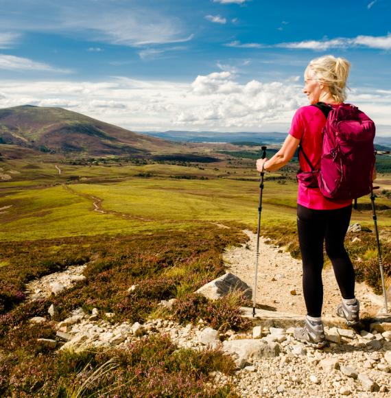 Woman stopping to admire the view on the trail in the Cairngorms National Park, Scotland.