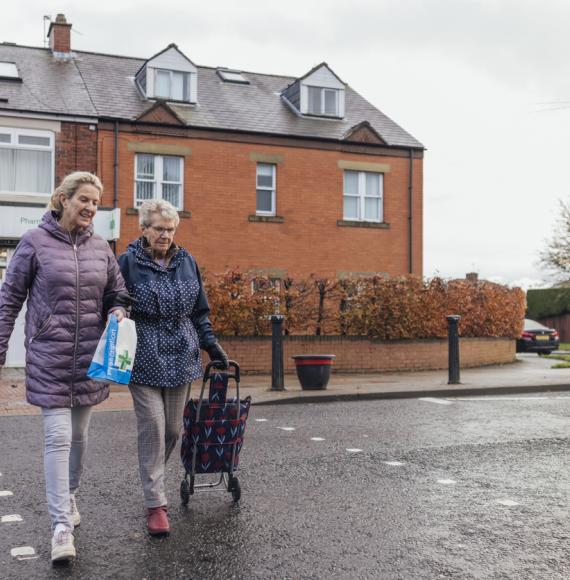 An elderly woman out with her unpaid carer