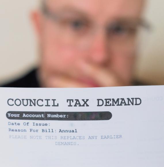 Worried man checking council tax bill