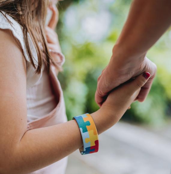 Girl holds adults hand