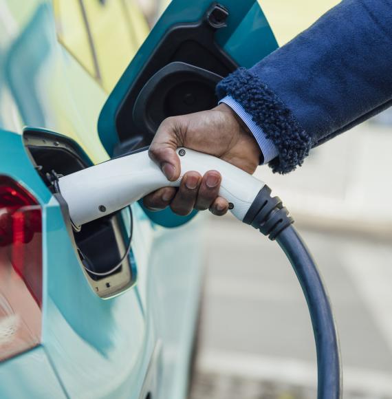 Man plugging an electric care into a charger