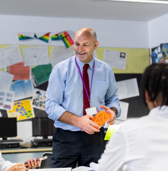 school teacher teaching his students in a high school